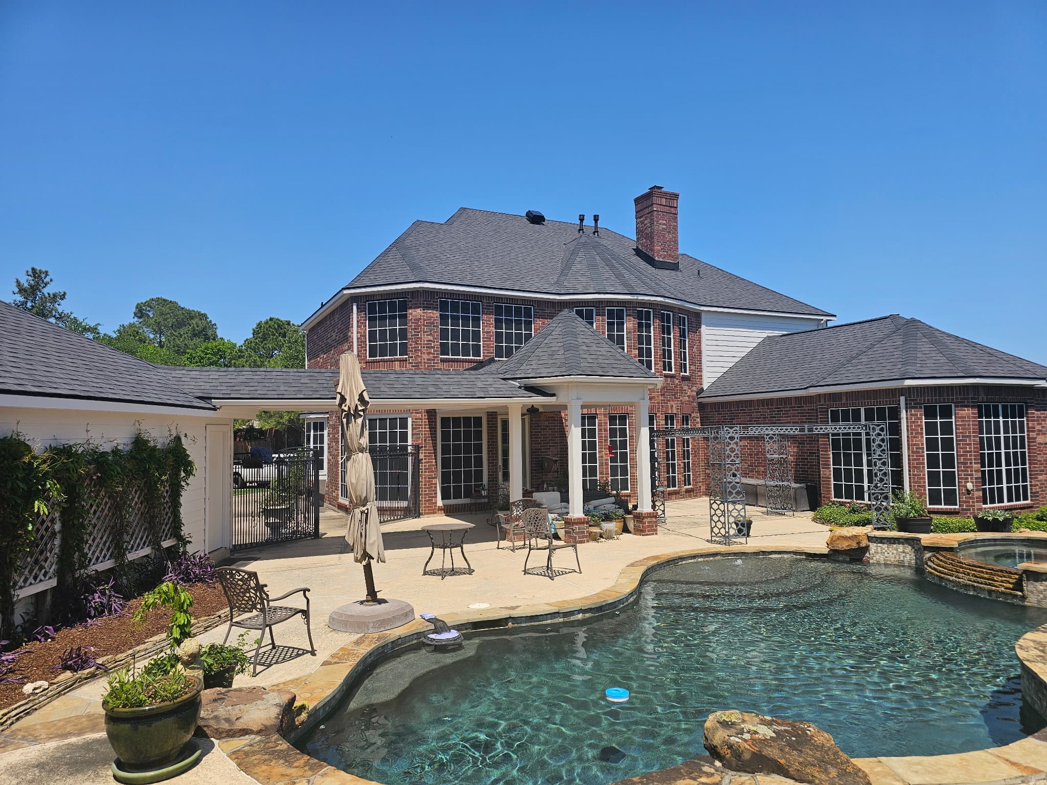 Jerrys Roofing crew performing professional roof replacement on a brick two-story home in Katy, Texas