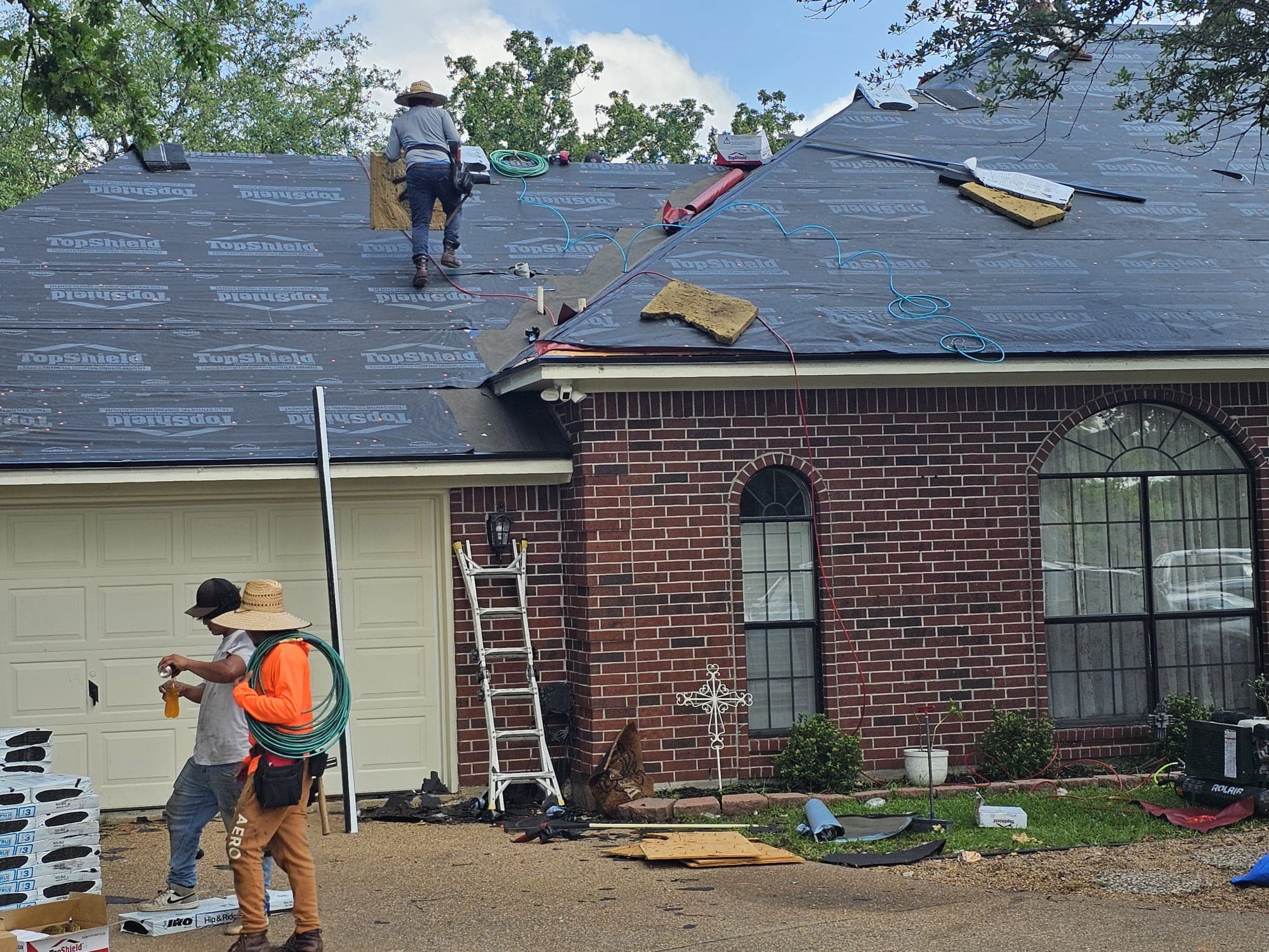 Jerrys Roofing crew installing synthetic underlayment on a brick home in Katy, Texas