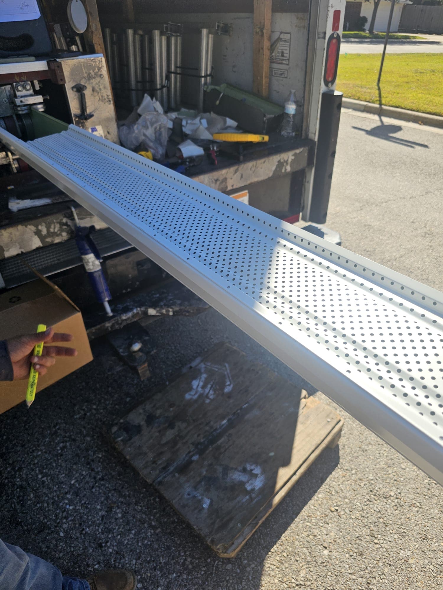 Seamless gutter being extruded on-site from the Jerrys Roofing truck in Katy, Texas